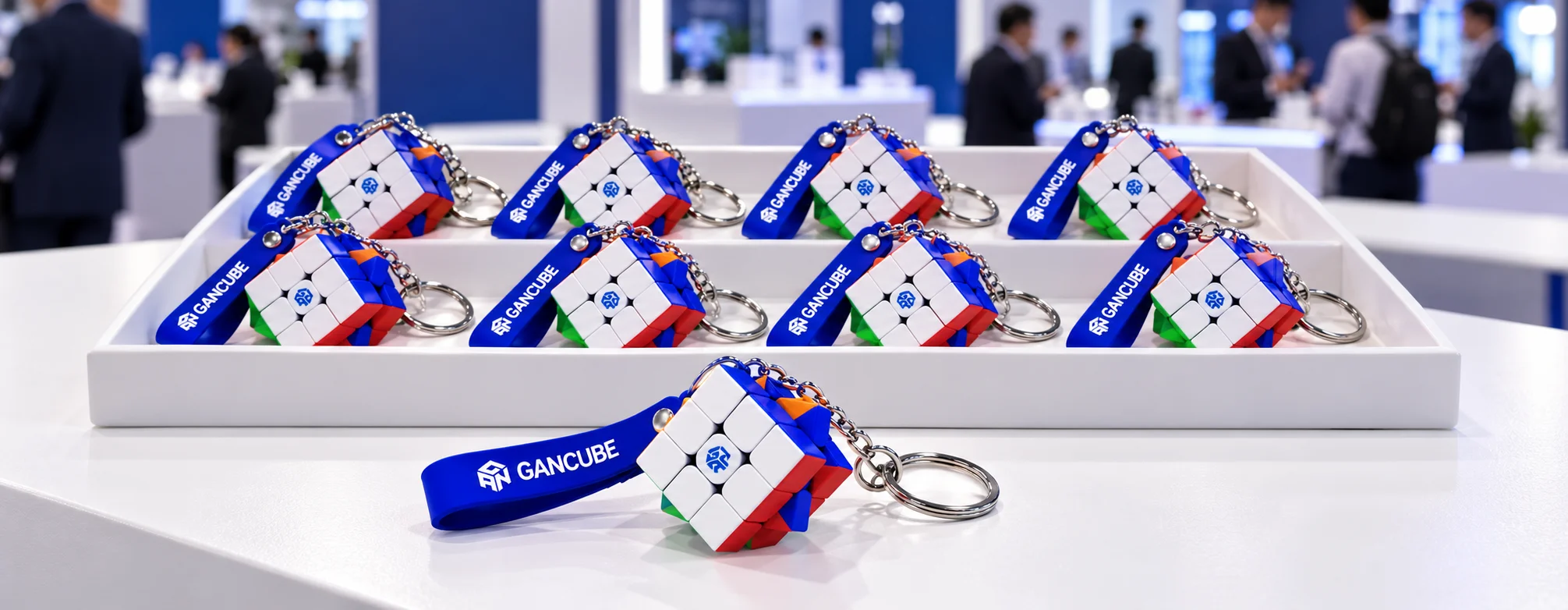 Tray of custom mini rubiks cube keychains arranged for promotional giveaways at a trade show booth 