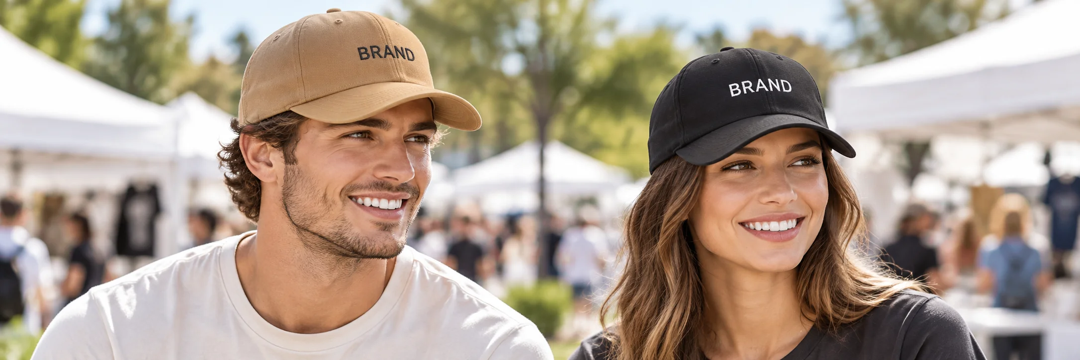 Two staff members wearing tan and black embroidered cotton caps at an outdoor event