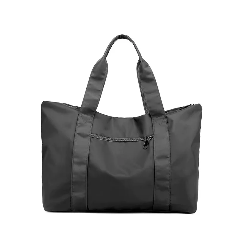 Black nylon duffel bag with two soft carry handles and a front zippered pocket on a white background