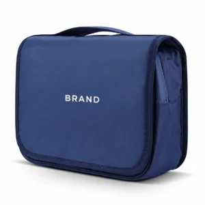 Closed navy toiletry organizer with white lettering, a fold-over front panel and top carry handle.