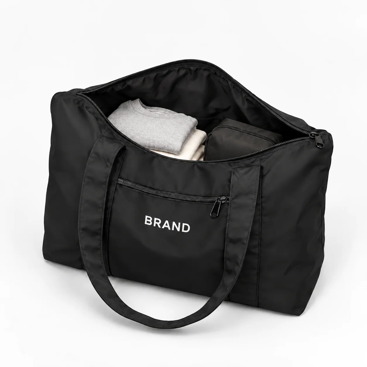 Open black nylon duffel with folded clothing inside its main compartment.