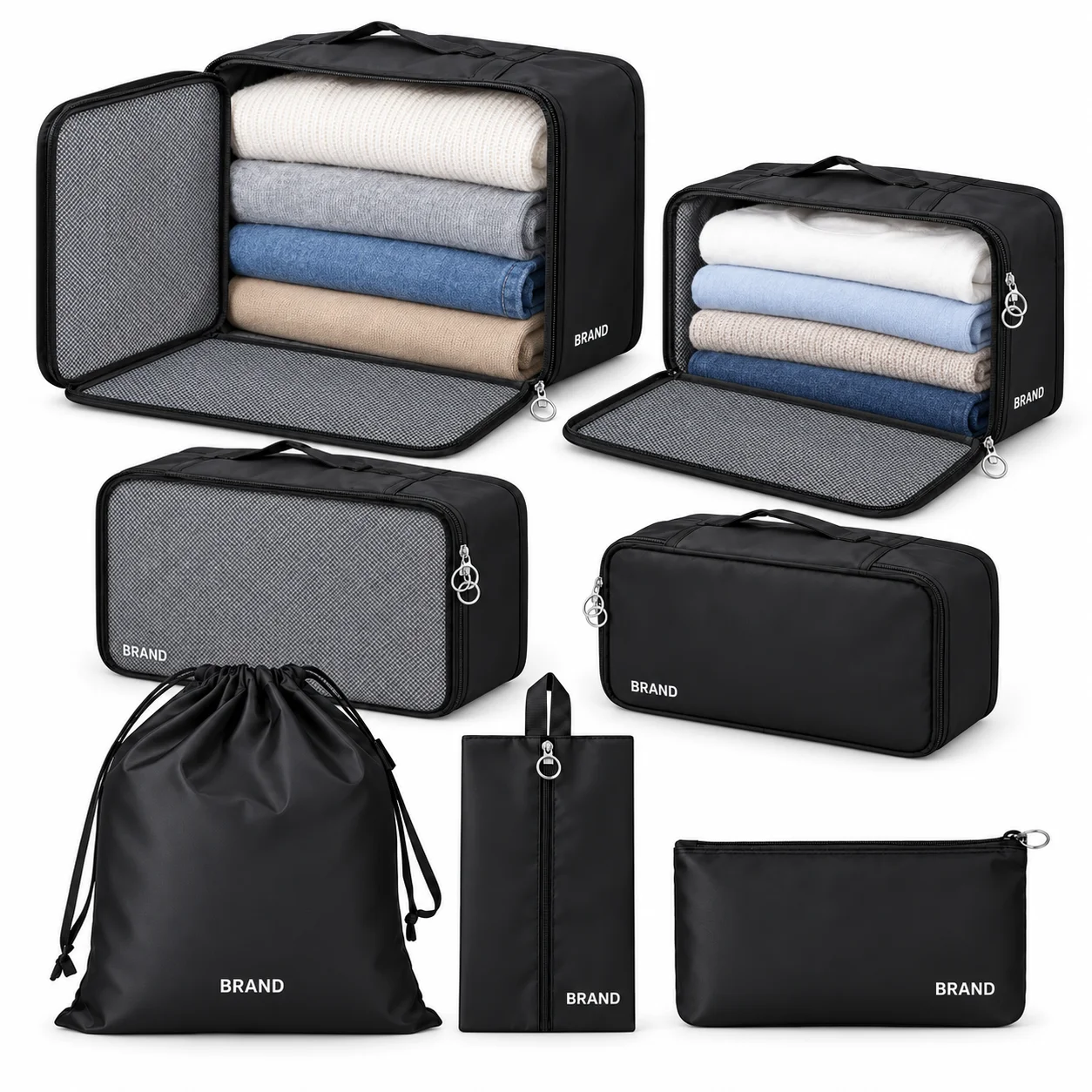 Two open black packing organizers with folded clothing beside the other five pieces of the travel set.