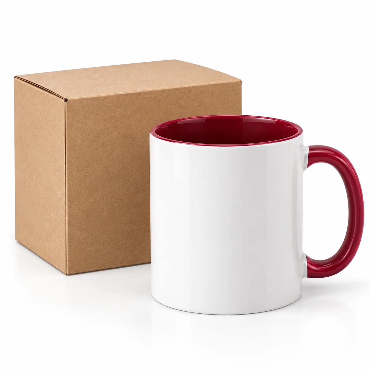 Plain white ceramic mug with a burgundy handle beside an unprinted kraft carton.