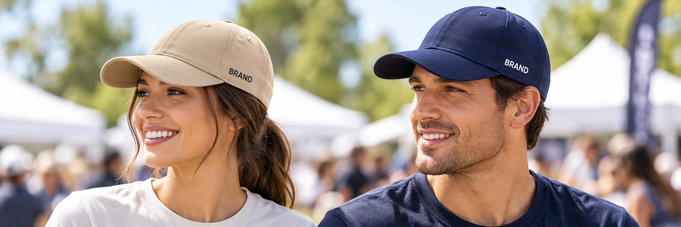 Two event staff members wearing beige and navy caps with visible left-panel lettering