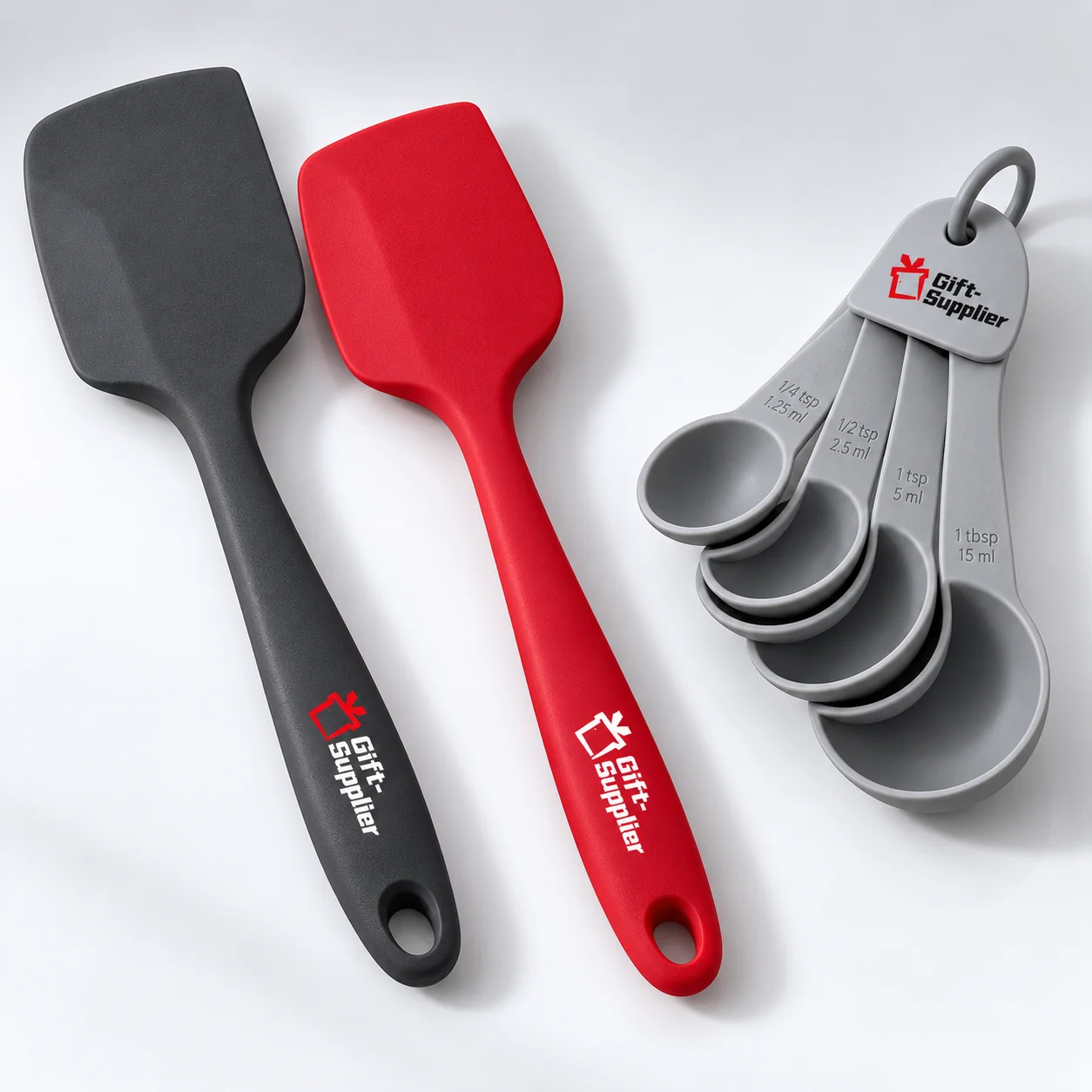 Silicone spatulas and a measuring spoon set with Gift Supplier logo details.
