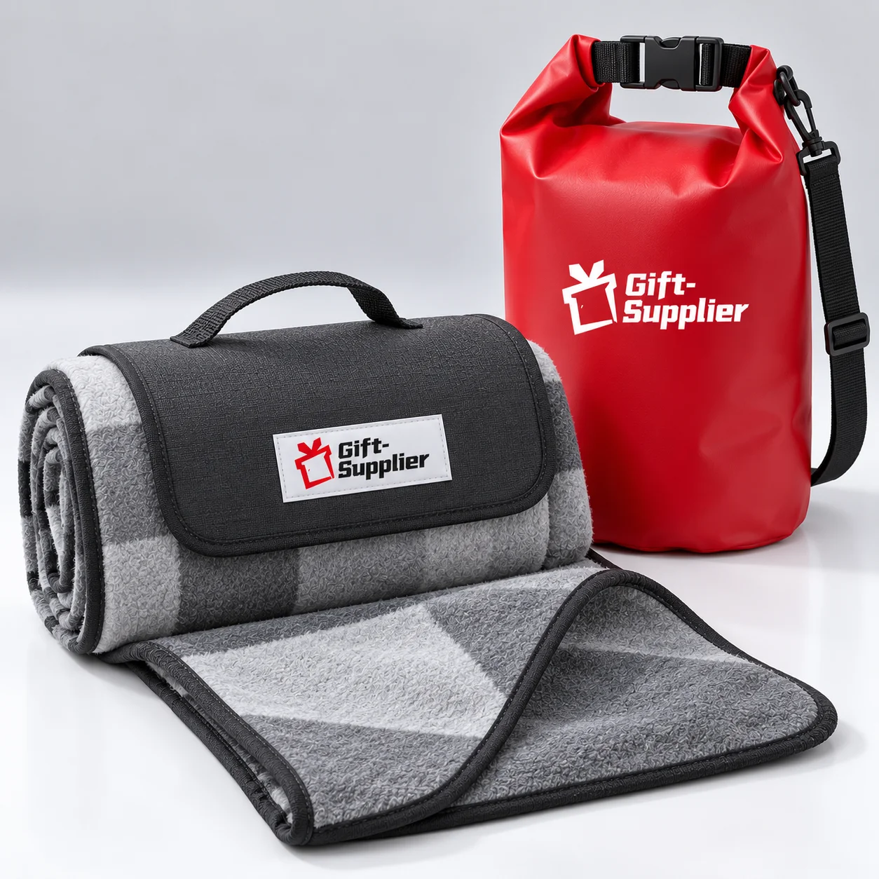 Foldable picnic blanket and deep-red roll-top dry bag with the Gift Supplier logo.