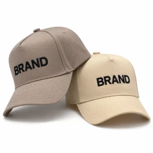 Taupe and beige baseball caps displayed side by side with embroidered front lettering