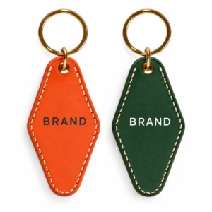 Orange and dark green PU leather keychains with printed lettering and gold-tone split rings